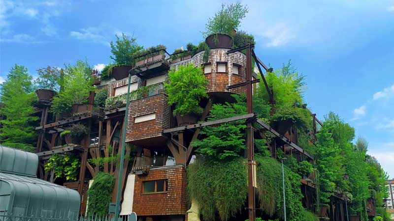 Blog Ambiental • Prédio residencial com arquitetura verde e árvores integradas na estrutura.