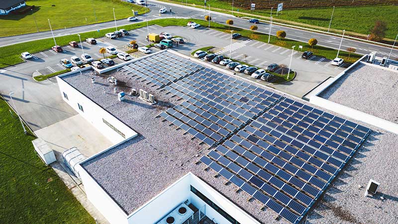 Centro comercial moderno com painéis solares no telhado, promovendo energia renovável e eficiência energética.