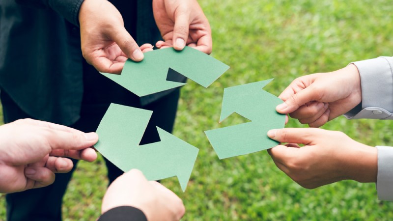 Blog Ambiental • Mãos unidas segurando setas de reciclagem em símbolo de economia circular